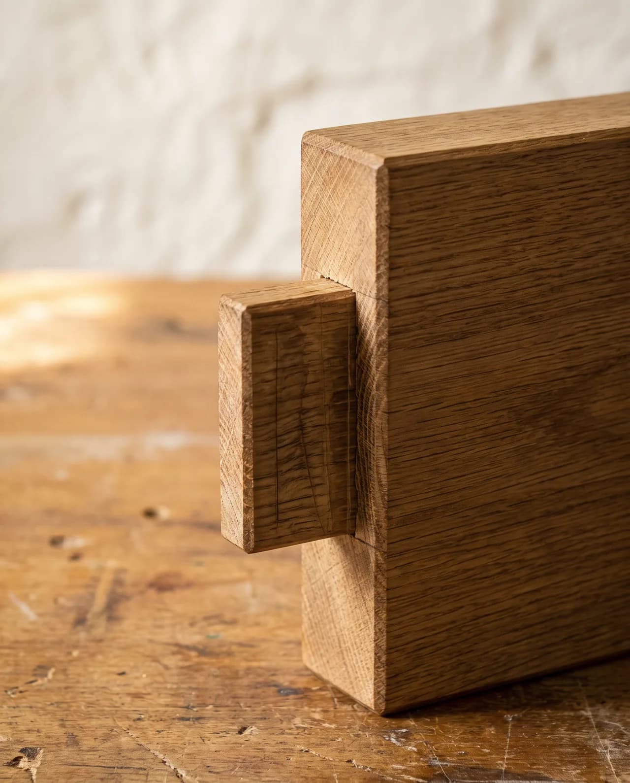 Joinery detail of a squared tenon on the end of a solid oak member with faint saw and chisel marks