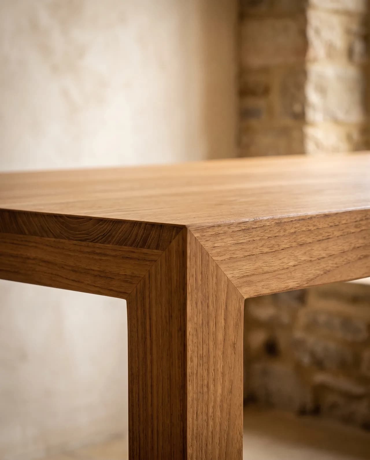 Close-up of dining table corner joinery and a hand-finished teak surface