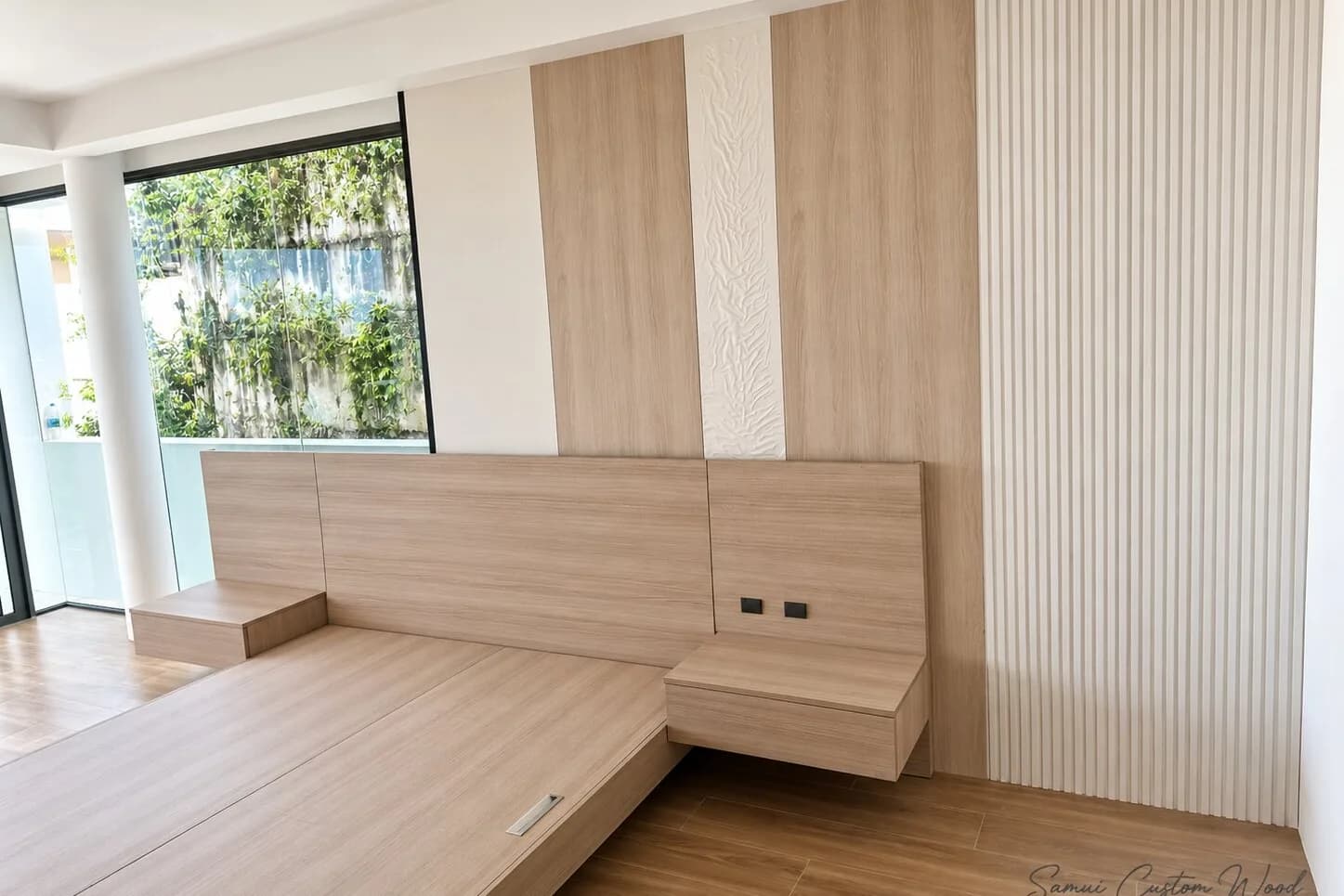 Platform bed with wide integrated headboard and floating nightstands against a panelled wall