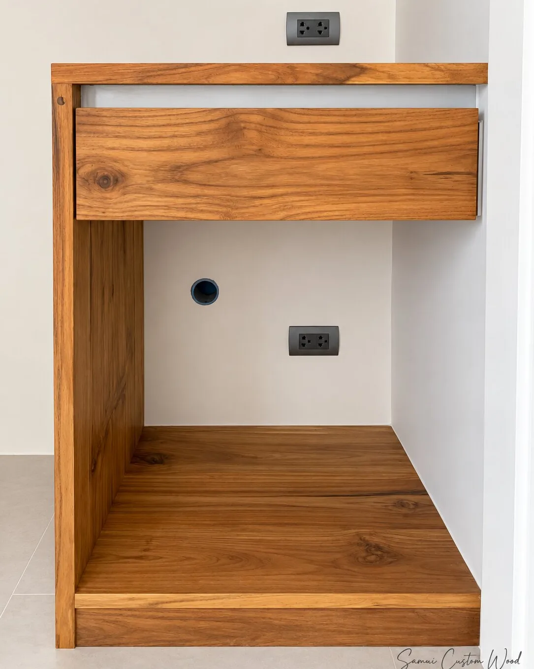 Solid teak bedside unit with a single drawer built into a wall niche