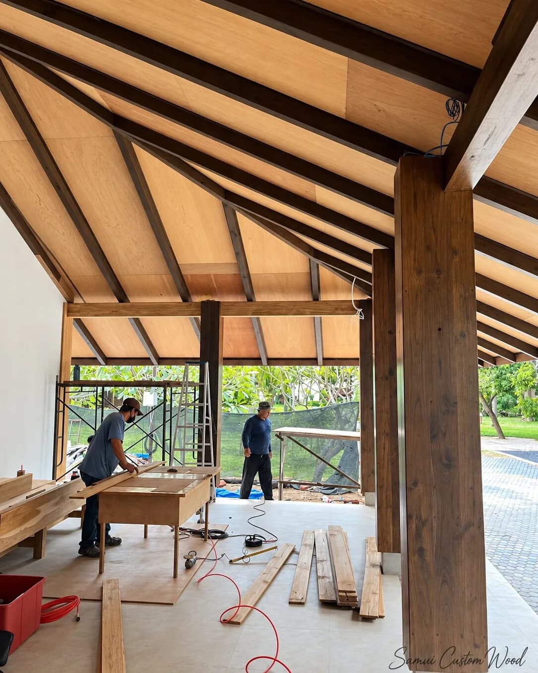 Pitched pavilion roof lined with light timber panels between dark rafters