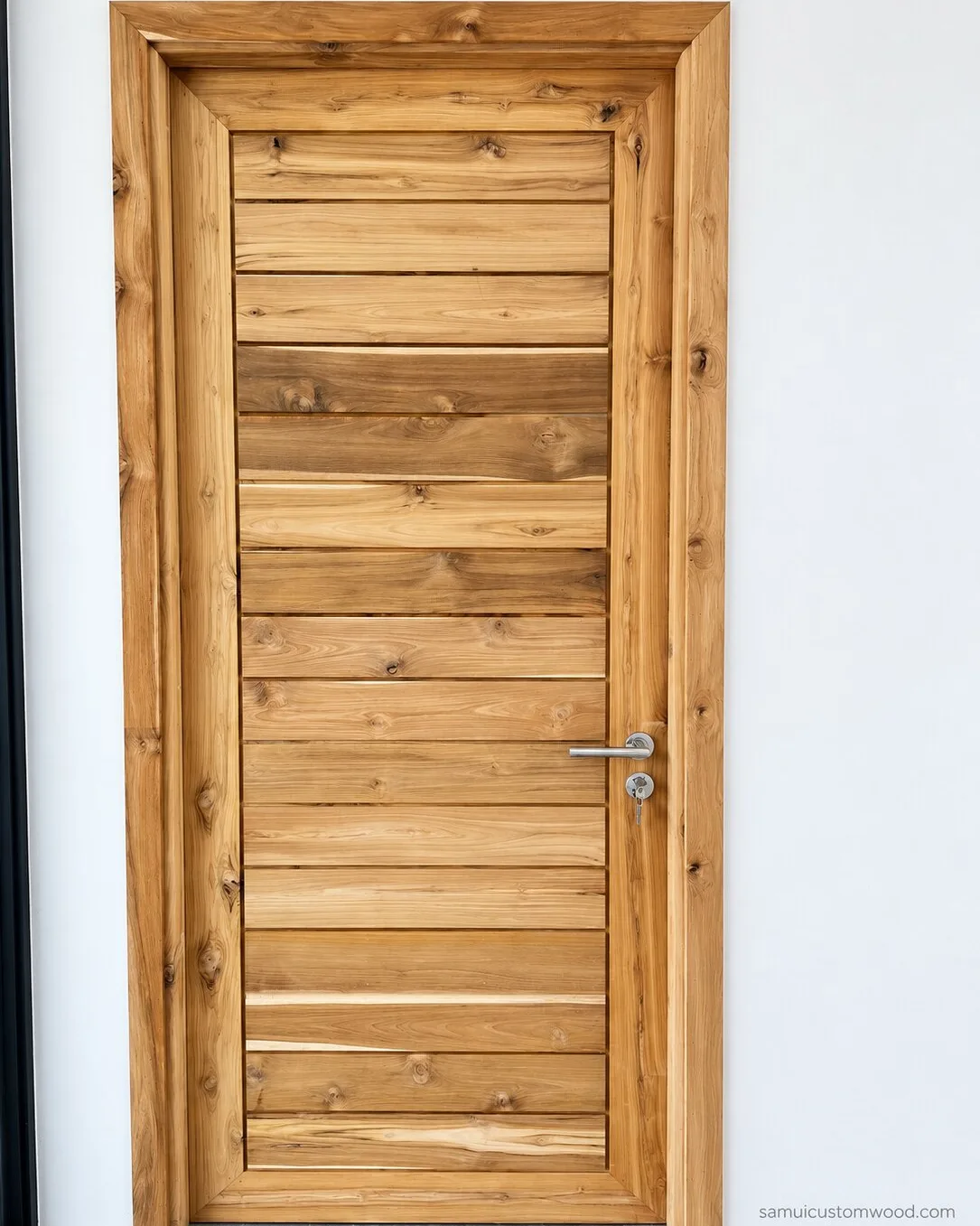 Horizontal-plank teak door hung in its solid teak frame after installation