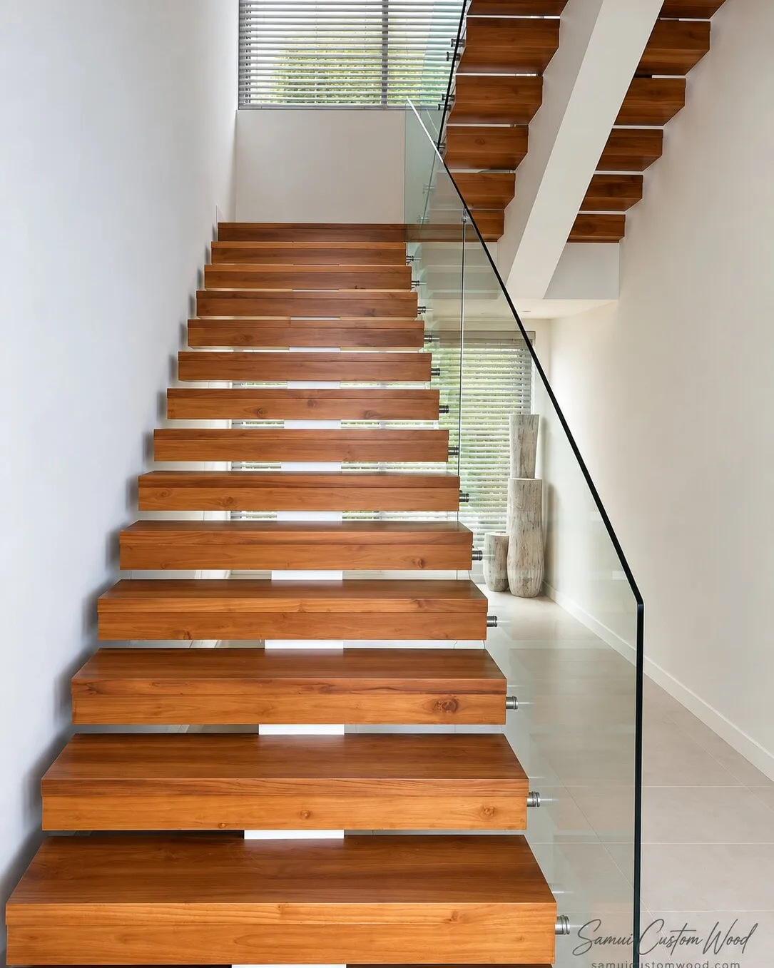 Floating timber staircase with cantilevered box treads and a glass balustrade