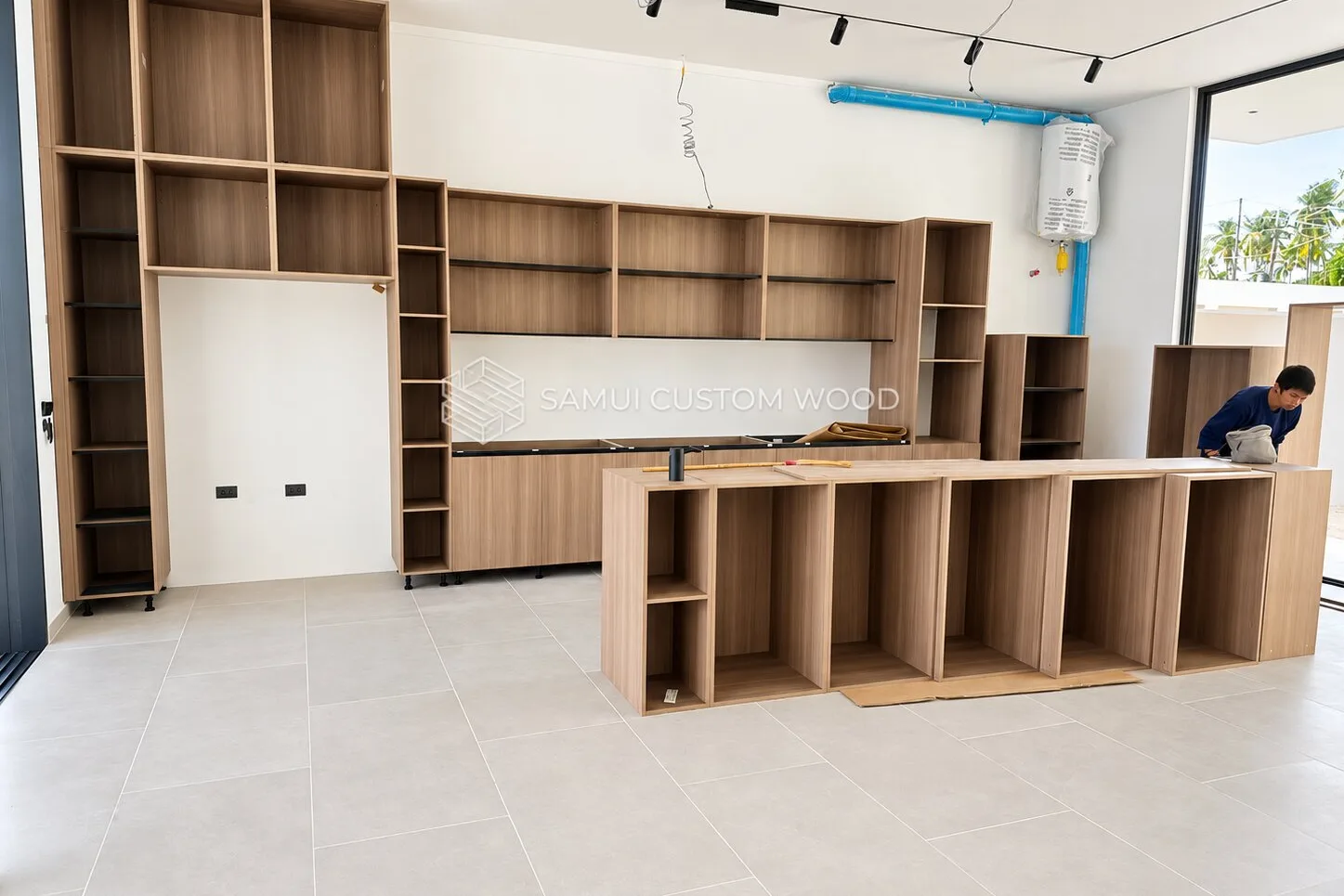 Wall of open cabinetry carcasses with shelving during a fit-out