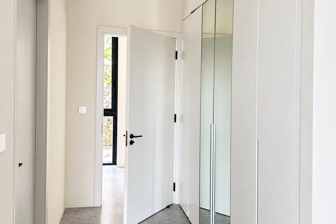 Corridor lined with full-height built-in wardrobes with tall mirror inserts