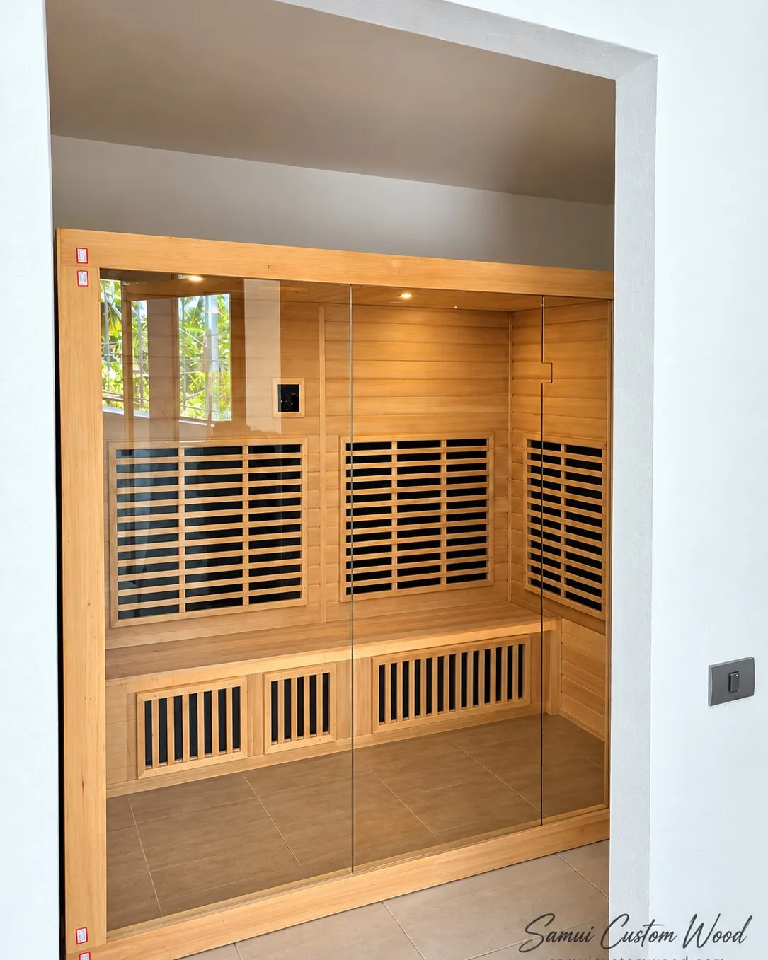 Timber sauna cabin with a full glass front fitted into a wall recess